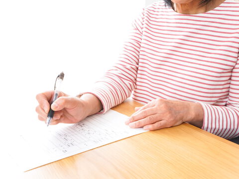 Frau füllt ein Formular mit einem Stift aus